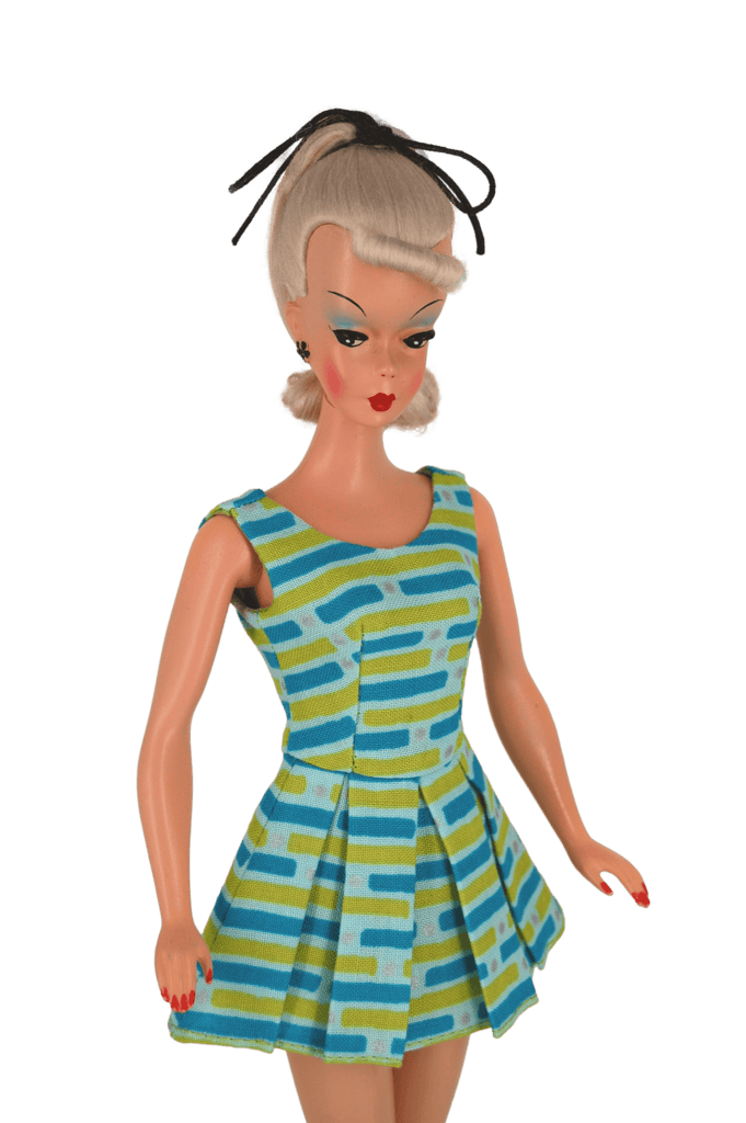 Bild Lilli doll in a blue and green geometric mini dress with a pleated skirt, showcasing bold vintage patterns and 1950s charm.