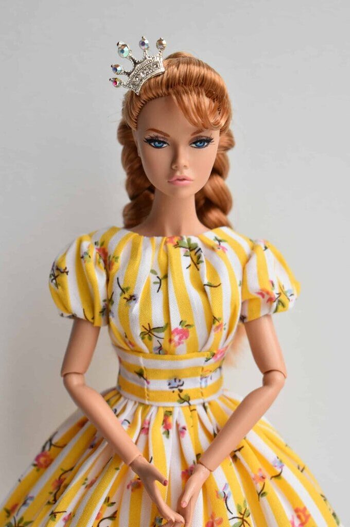 Yellow and white striped vintage doll dress with floral print, puffed sleeves, fitted bodice, and full pleated skirt. Handmade collectible doll fashion with retro elegance.