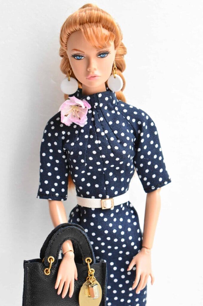 Elegant navy blue polka dot sheath dress with high neckline and white belt, designed for vintage-inspired fashion enthusiasts.