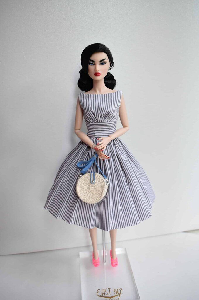 Classic vintage-style doll dress in a sleek pinstripe pattern, featuring a boat neckline, pleated detailing, and a full skirt that exudes refined elegance and femininity.