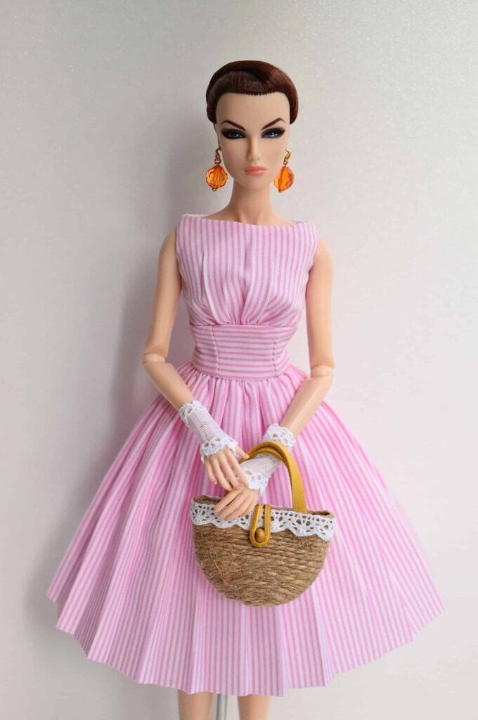 Retro-inspired pink and white striped doll dress with a gracefully gathered bodice, cinched waist, and voluminous pleated skirt for a timeless, feminine appeal.Retro-inspired pink and white striped doll dress with a gracefully gathered bodice, cinched waist, and voluminous pleated skirt for a timeless, feminine appeal.